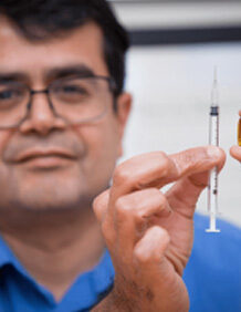 Samir Mitragotri holds a syringe and a pill. Image credit Eliza Grinnell.