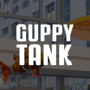 Guppy Tank text overlaid on an event image from the LabCentral lobby.